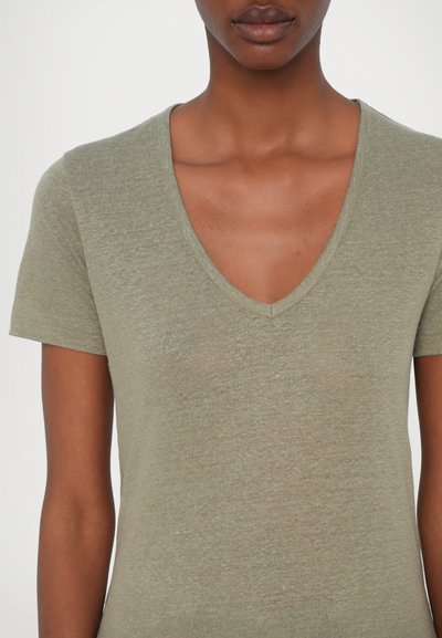Olivgrön t-shirt med kort ärm, V-ringning, mjuk textur, subtilt stickat mönster, åtsittande form med lätt strukturerad yta.