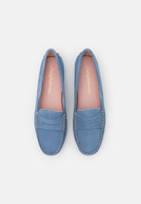 Sinised sametist loafers, millel on sile tekstuur, dekoratiivne tikand äärtes ning roosa sisetald, millel on trükitud brändinimi.