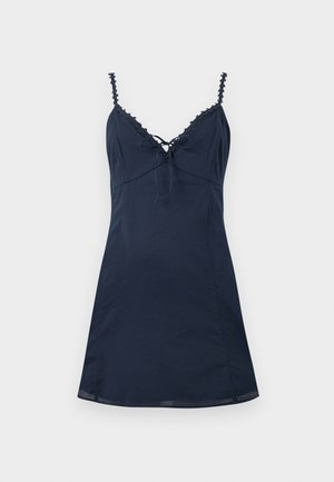 Meresinine varrukateta kleit pitsäärisega kaelusega, reguleeritava ees oleva lipsusõlmega ja kitseneva vöökohaga, laotatud helel taustal.