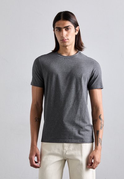 Graues T-Shirt mit kurzen Ärmeln aus weichem Stoff, mit Rundhalsausschnitt und schmaler Passform, getragen mit hellen Hosen.