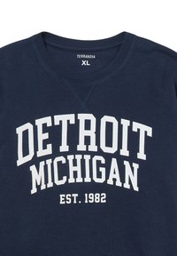 Granatowy sweter z okrągłym dekoltem wykonany z miękkiego materiału, z napisem "DETROIT MICHIGAN EST. 1982" dużymi białymi literami na przodzie.