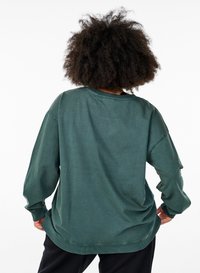 Felpa oversize verde scuro, maniche lunghe, scollatura rotonda, texture morbida, design minimalista con polsini e orlo a coste.
