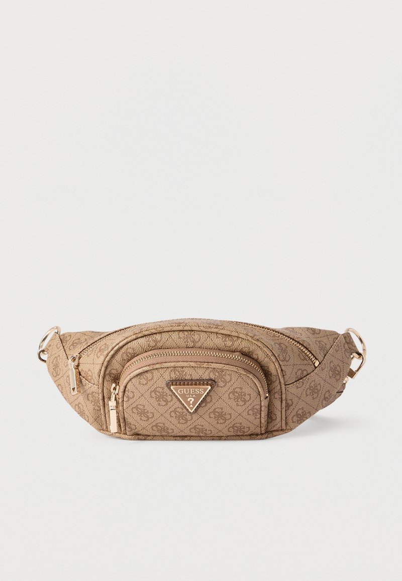 Banane beige Guess monogramme avec poche avant zippée, fermetures éclair dorées et sangle réglable sur fond blanc.