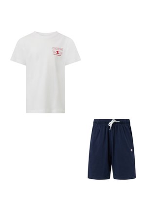 Camiseta blanca de manga corta con logo y texto rojo de Champion, combinada con pantalones cortos azul marino con cordón y pequeño logo de Champion en la pierna.