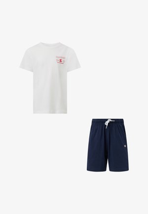 T-shirt blanc à manches courtes avec logo Champion rouge et texte, associé à un short bleu marine à cordon de serrage avec petit logo Champion sur la jambe.