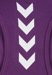 Purpurowa tkanina z czterema ułożonymi jedna na drugiej białymi, skierowanymi w dół strzałkami w kształcie litery V i widocznym przeszyciem na bokach.