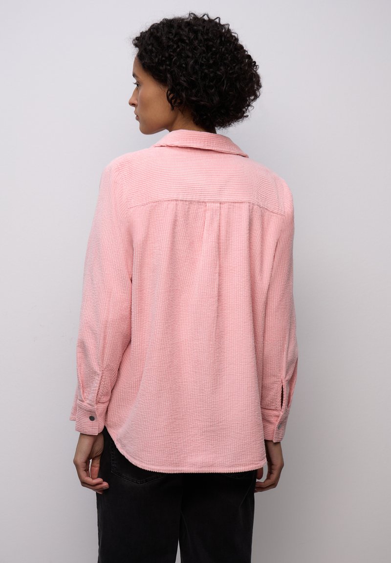 Jasnoróżowa, teksturowana koszula z kołnierzem, długimi rękawami i ozdobnymi guzikami, o luźnym kroju i zaokrąglonym dołem.