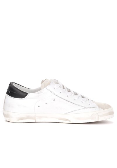 Sneaker bianchi in pelle con un accento nero sul tallone, dotati di una punta in camoscio, lacci rotondi e piccole perforazioni sui lati.
