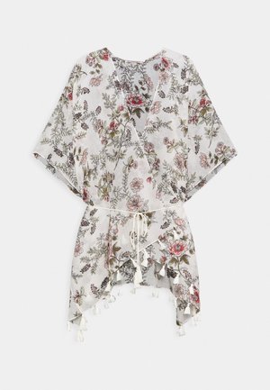 Witte gebloemde wikkeljurk met roze en rode bloemen, korte brede mouwen, zoom met kwastjes en een dun gevlochten taillekoord.