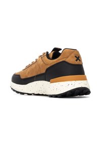Zapatillas de ante marrón y sintético negro con una entresuela blanca moteada, cordones redondos y una suela de goma texturizada. Presenta un logo en el talón.
