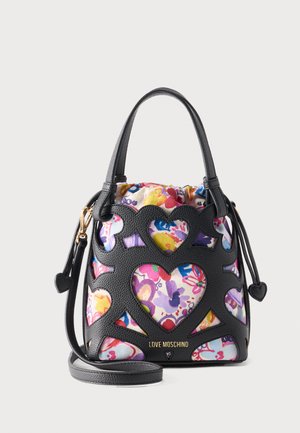 Torebka Moschino Black Love z wycięciami w kształcie serc, odsłaniającymi kolorową, kwiatową podszewkę, posiadająca górne uchwyty i odpinany pasek.