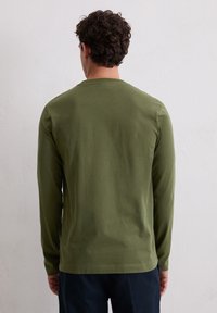 Długi rękaw T-shirt w oliwkowozielonym kolorze z bawełny, z okrągłym dekoltem i gładką teksturą. Prosty design bez widocznych wzorów ani akcentów.