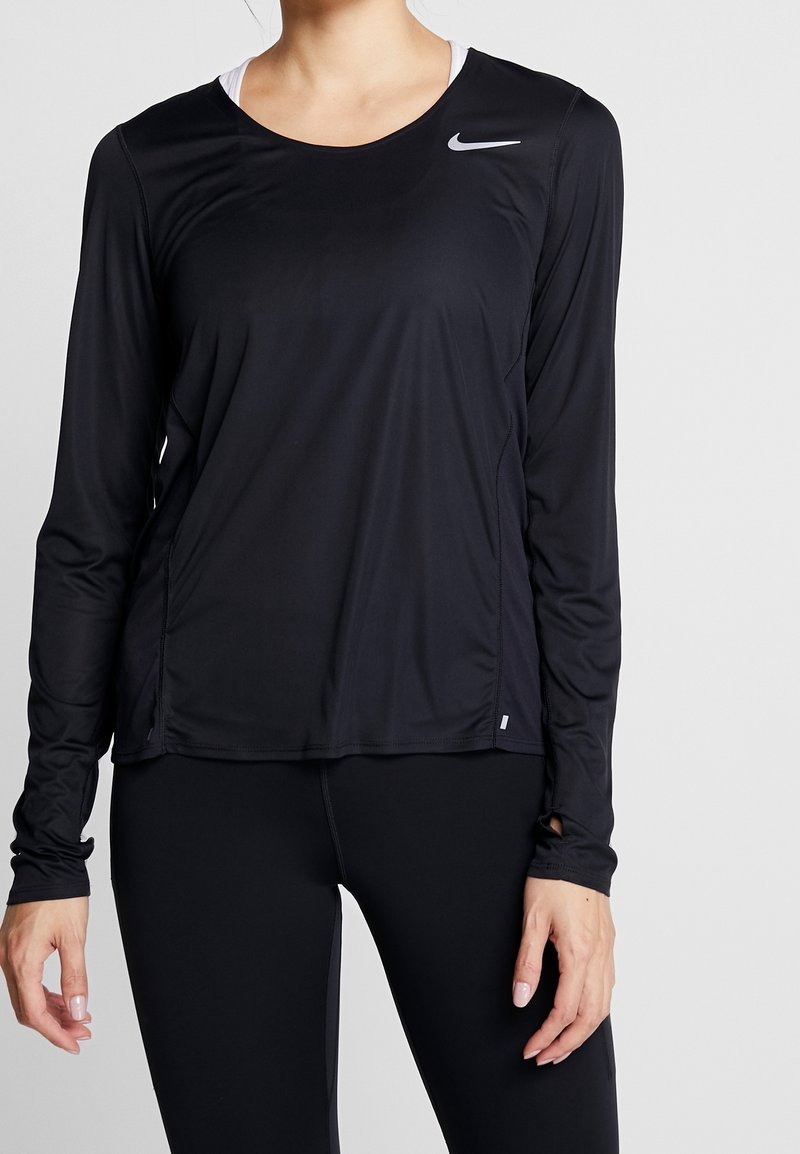 Mustapaita, jossa on pitkät hihat, valmistettu kevyestä kankaasta, pyöreä kaula-aukko ja pieni valkoinen logo vasemmassa olkapäässä.