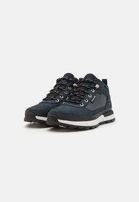 Men's hiking shoes in navy suede with black accents, featuring textured laces, a padded collar, and a white, cushioned sole.