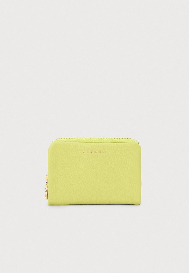 Μικρό λευκό δερμάτινο πορτοφόλι σε φωτεινό πράσινο χρώμα με χρυσό φερμουάρ και ανάγλυφο λογότυπο στο κέντρο του μπροστινού μέρους σε απλό φόντο.