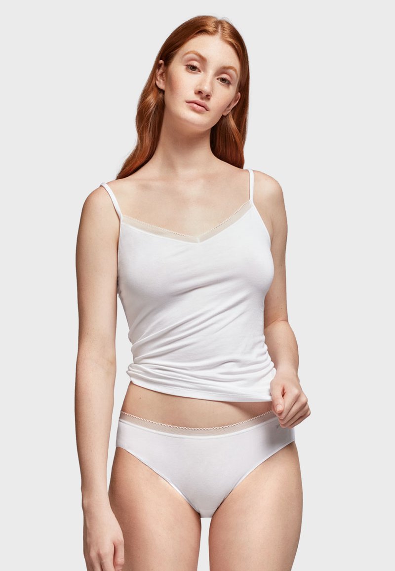 Witte katoenen top met dunne bandjes en een V-halslijn, gecombineerd met witte slipjes met een delicate scalloped tailleband.