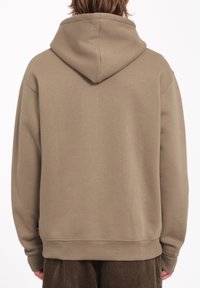Sudadera con capucha en color caqui, fabricada en tejido suave. Presenta un corte holgado, puños de canalé y un dobladillo recto. Diseño minimalista sin gráficos.