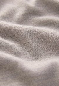 Light gray fabric with a fine knitted texture, featuring soft, rounded folds and subtle variations in color across the surface.