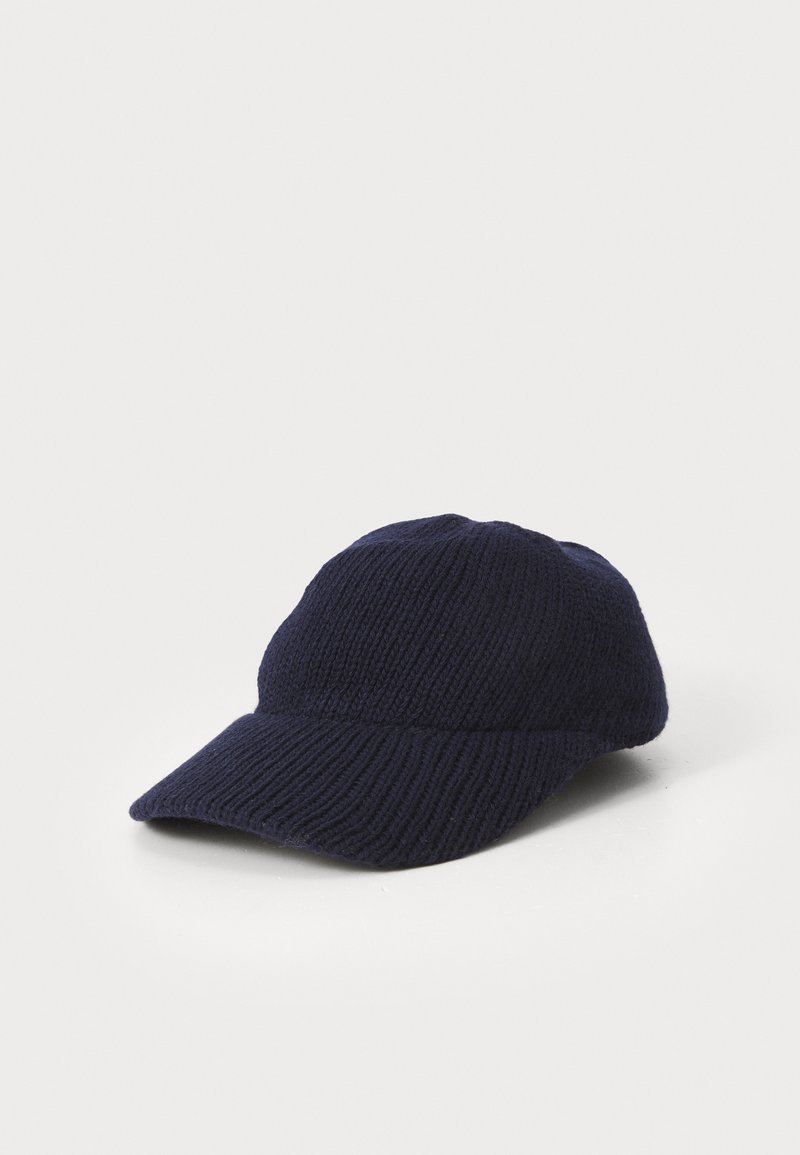 Bonnet en tricot bleu marine avec une visière courbée, présentant un tissu texturé et un ajustement confortable. Design simple sans motifs ni éléments supplémentaires.