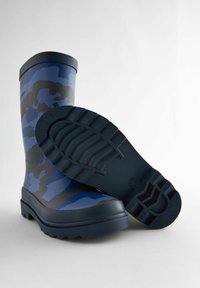 Botas de lluvia de camuflaje en azul y gris, fabricadas en caucho, con una suela texturizada y una parte superior redondeada. La suela tiene un diseño de tachuelas profundas para mayor tracción.
