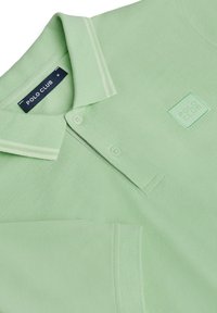Jasnozielona koszulka polo wyróżnia się teksturowanym materiałem, miękkim kołnierzykiem z białymi paskami, małą kieszonką na piersi oraz haftowanym logo "POLO CLUB".