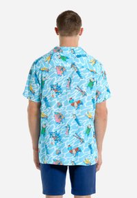 Light blue short-sleeve shirt featuring a multicolored cartoon pattern and a relaxed fit. Made from breathable fabric with a camp collar.