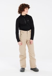 Maglietta nera a maniche lunghe con scollatura a zip, pantaloni da neve beige con vita alta e tasca con zip, stivali invernali neri.