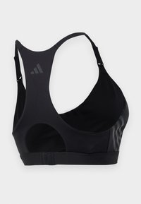 Svart sports-bh med racerback-design, laget av glatt stoff. Har en logo på siden og teksturerte detaljer på den ene siden. Justerbare stropper.