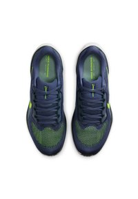 Un paio di scarpe da corsa Nike blu navy e verde neon con lacci, viste dall'alto su uno sfondo bianco.
