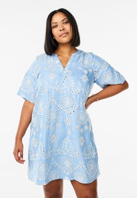 Robe brodée bleu clair avec un décolleté en V, des manches courtes, des motifs floraux et des détails en œillets sur l'ensemble du tissu.