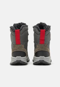 Botas de tobillo en tela gris con forro suave, detalles en ante marrón y tiradores rojos; con suela de goma texturizada en gris y negro.