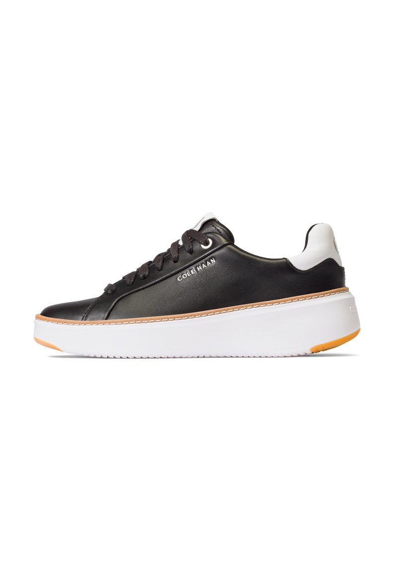 Schwarzer synthetischer Sneaker mit weißer Zwischensohle, orangefarbenem Außensohlen-Detail und flachen Schnürsenkeln. Verfügt über eine glatte Oberfläche und dezente Markenkennzeichnung an der Seite.