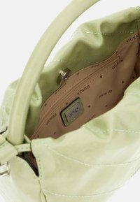 Borsa a mano verde chiaro con una finitura testurizzata, dotata di un interno beige con una tasca con zip e un motivo con logo ripetuto. Dettagli in metallo argentato.