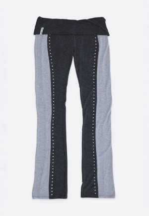 Κολάν με ζώνη που διπλώνει, με σκοτεινά γκρι κεντρικά πάνελ, ανοιχτό γκρι πλαϊνά πάνελ και μικρές λευκές τελείες που διακοσμούν τα σκοτεινά τμήματα.