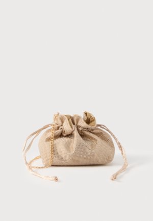 Pochette beige à cordon, recouverte de petits clous, avec une chaîne dorée et de longues bandoulières en tissu.