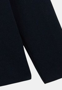 Tissu tricoté bleu marine foncé avec une surface texturée et un ourlet de manches arrondi, mettant en avant un design simple et fonctionnel.