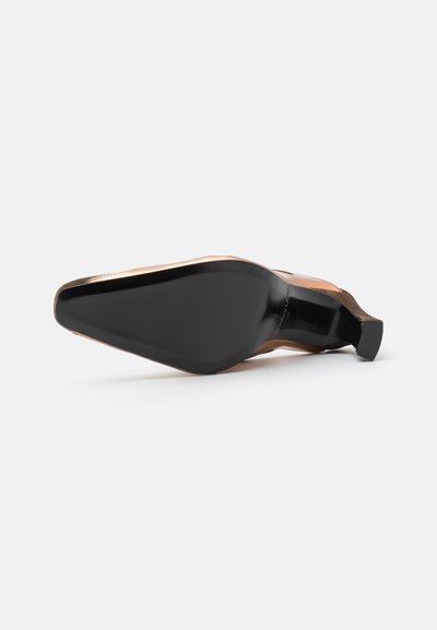 Chaussure à talon haut en cuir tan avec un bout pointu et une semelle en caoutchouc noir. Présente un talon fin et un design minimaliste.