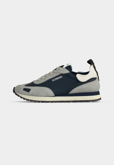 Baskets basses avec panneaux bleu marine et gris clair, semelle blanche, lacets à motifs, logo "ICEBERG" sur le côté et languette de talon noire.