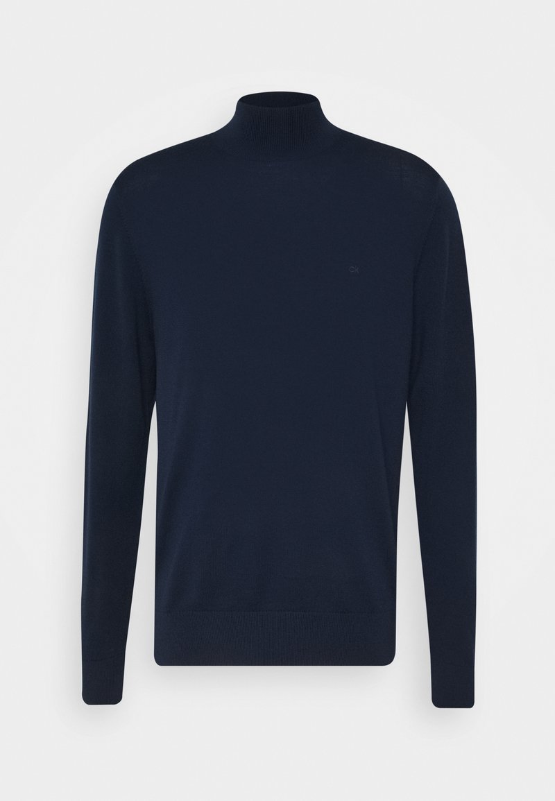 Marinblå polotröja i mjukt stickat tyg. Har långa ärmar, en figursydd krage och en subtil logotyp på bröstet. Enkel design.
