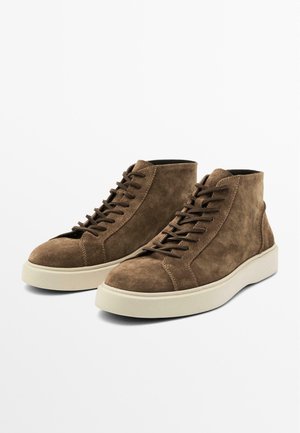 Bruine suède high-top sneakers met rubberen zolen, voorzien van een vetersluiting en versterkte stiksels langs de zijkanten.