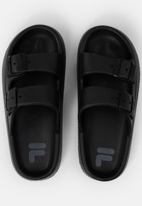 Svarte sandaler med to justerbare stropper med spenner, teksturerte s�åler og en perforert overflate for pusteevne. Logo trykt i grått.