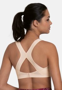 Lys pink sports-bh med et åndbart mesh-stof, racerback-design og flade sømme for komfort. Justerbar hægtelukning bagpå.