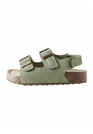 Grüne Wildleder-Sandale mit offenen Zehen, zwei verstellbaren Schnallenriemen und einem Fersenriemen über einer Korksohle.