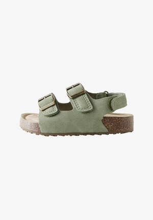 Grüne Wildleder-Sandale mit offenen Zehen, zwei verstellbaren Schnallenriemen und einem Fersenriemen über einer Korksohle.
