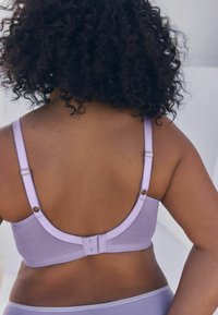 Lila bralette z nastavljivimi naramnicami, zaponko na kljuko in očesce ter gladkim materialom. Ima dekorativno šivanje in zlate kovinske dodatke.