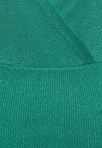 Teal brei-stof met fijne ribbels en subtiele metalen draden, die een gestructureerd patroon op het oppervlak creëren.