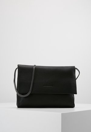 Black leather shoulder bag with fold-over flap and braided strap, placed on a white surface against a plain gray background.
