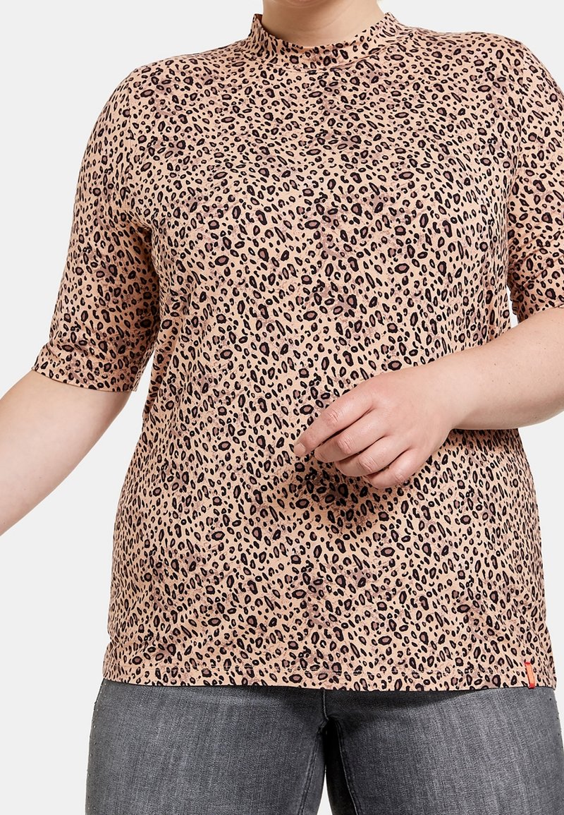 Haut à manches courtes en imprimé léopard dans une teinte rose clair, présentant un col haut et une coupe décontractée, fabriqué en tissu doux et léger.