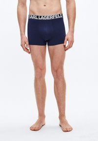 Granatowe bokserki z bawełny z czarnym pasem w talii ozdobionym białym napisem "KARL LAGERFELD". Miękka tekstura, dopasowany krój, bez wzorów.