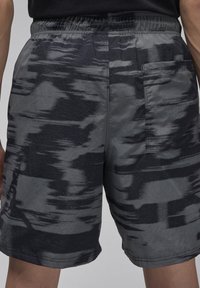 Pánské šortky v šedém a černém abstraktním vzoru, vyrobené z lehkého materiálu, s elastickým pasem a jednou zadní kapsou.